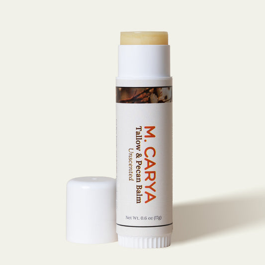 Open M. Carya Tallow and Pecan Balm showing light yellow balm inside white 0.6 oz tube