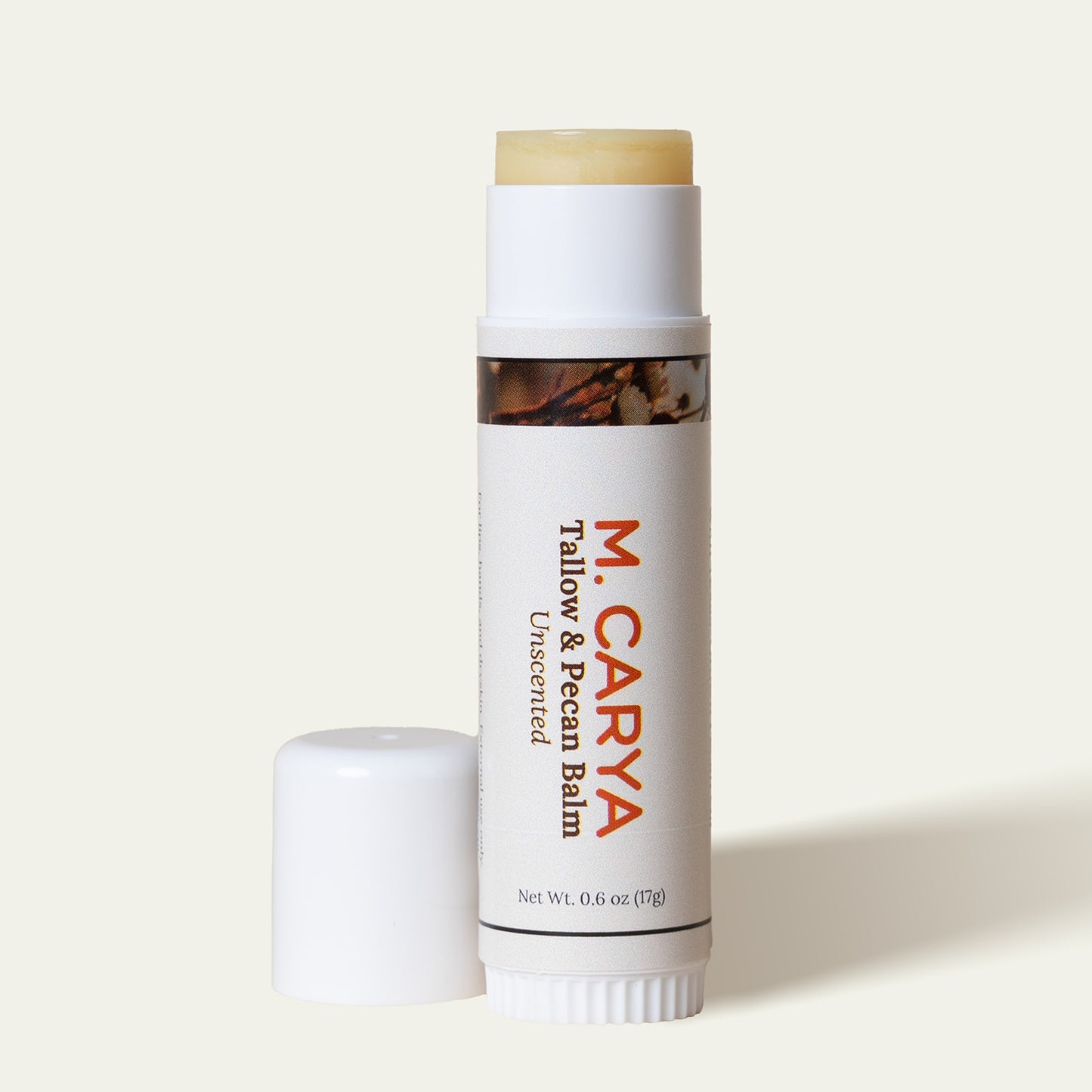 Open M. Carya Tallow and Pecan Balm showing light yellow balm inside white 0.6 oz tube
